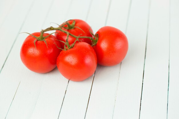 Tomate em um galho em uma madeira.