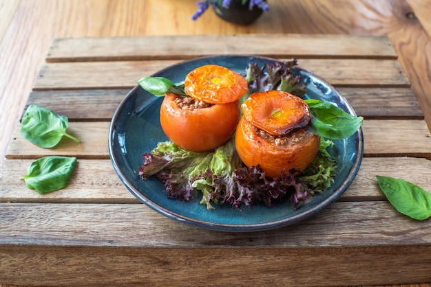 Tomate entero relleno con chili de carne molida en mesa de madera