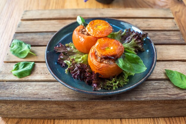 Tomate entero relleno con chili de carne molida en mesa de madera