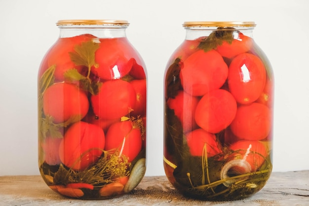 Tomate en escabeche en frascos de vidrio sobre mesa de madera. Copiar, espacio vacío para texto