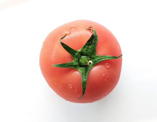 Tomate fresco húmedo aislado en blanco