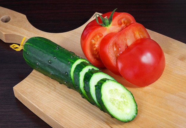 Tomate fresco maduro e pepino em um fundo de madeira