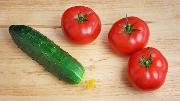 Tomate fresco y pepino sobre un fondo de madera