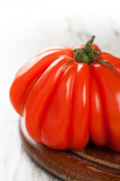 Tomate fresco en el viejo tablero de madera.