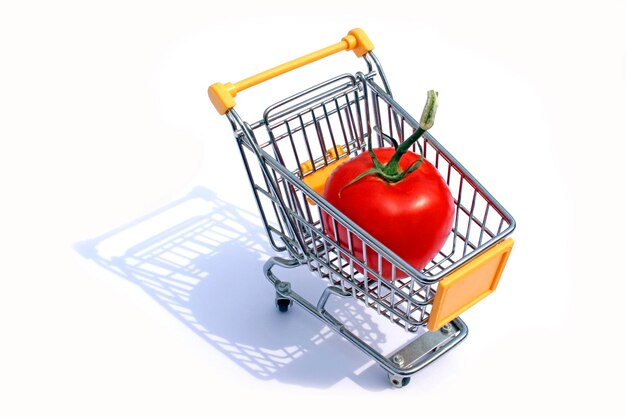 Foto tomate gigante en un carrito de compras