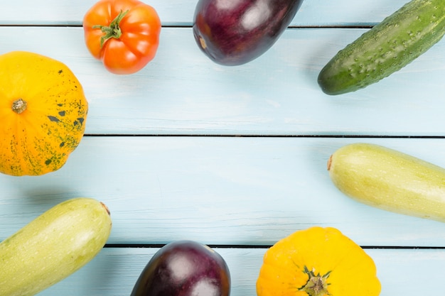 Tomate, Gurken, Buschkürbise, Auberginen und Mark auf blauem Holztisch mit copyspace Hintergrund