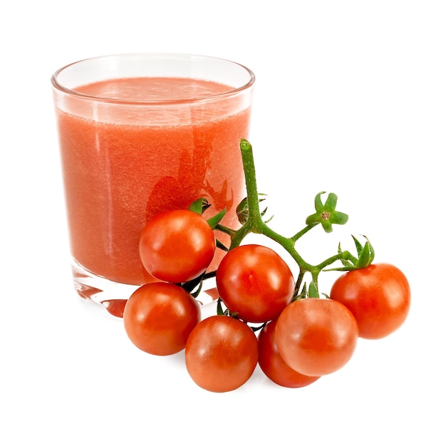 Tomate in einem Glas und einem Bündel Tomaten entsaften