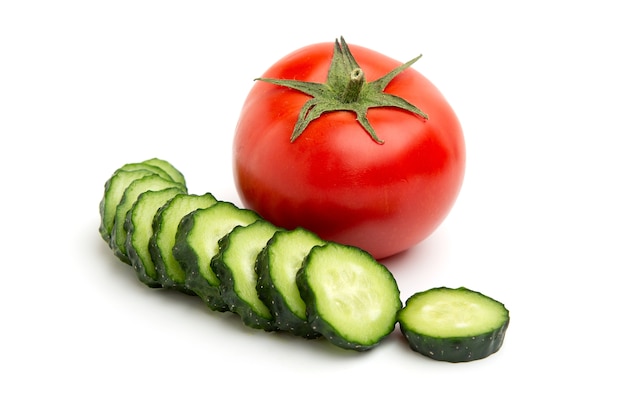 Tomate inteiro vermelho brilhante e fatias de pepino verde inteiro isolado em um branco isolado