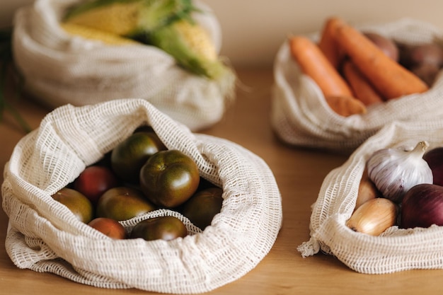 Tomate en lona bolsa de supermercado verduras en bolsas de algodón ecológico reutilizables sobre mesa de madera cero residuos