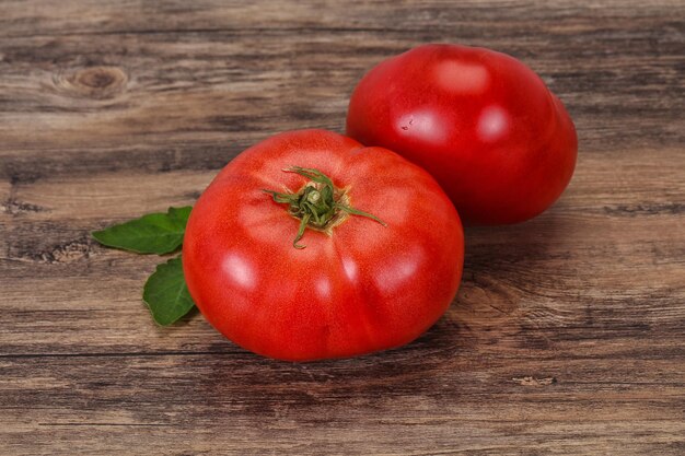 Tomate maduro sobre fundo de madeira