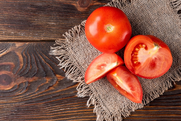 Tomate en mesa de madera oscura.