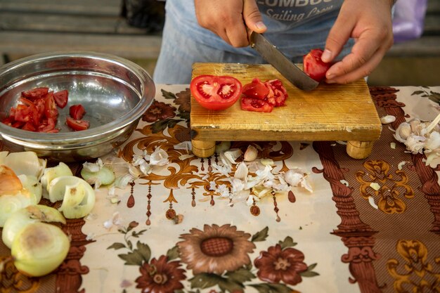 Un tomate por la mitad cortado en una tabla de cortar