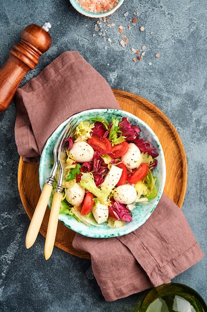 Tomate mozzarella y mezcla de hojas de ensalada fresca mesa de piedra pizarra