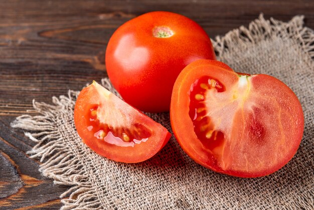 Tomate na mesa de madeira escura.