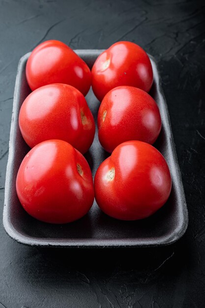 Foto tomate orgânico vermelho fresco no fundo preto