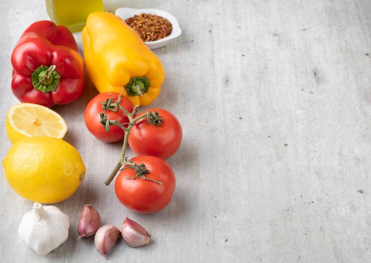 Foto tomate, pimentão, azeite, limão silício e alho sobre uma mesa de madeira com espaço de cópia. comida mediterrânea.