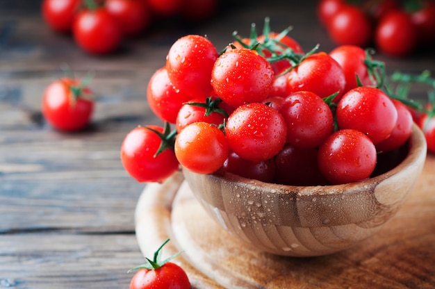 Tomate rojo cereza en la mesa de madera, enfoque selectivo