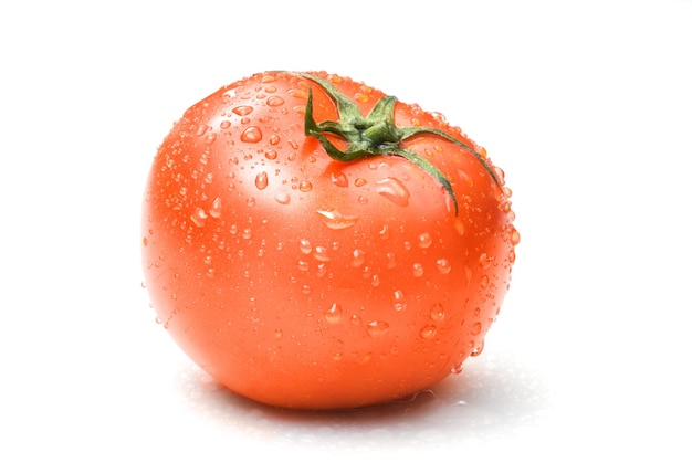 Tomate rojo con gotas de agua aislado en blanco