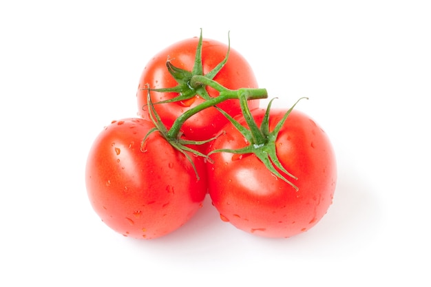 Tomate rojo con gotas aisladas sobre fondo blanco.