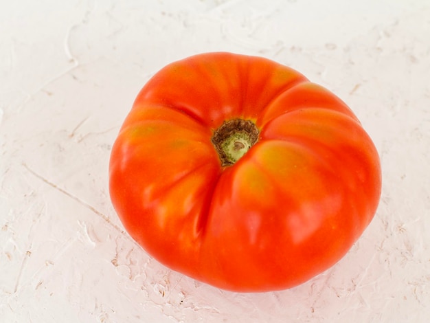 Tomate rojo maduro sobre un fondo blanco.