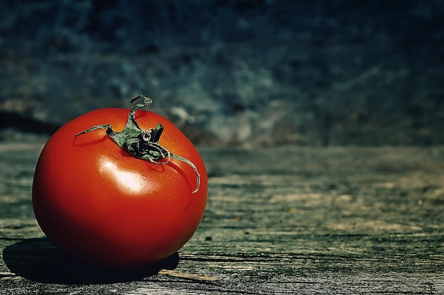 Foto tomate rojo sobre fondo de madera con textura