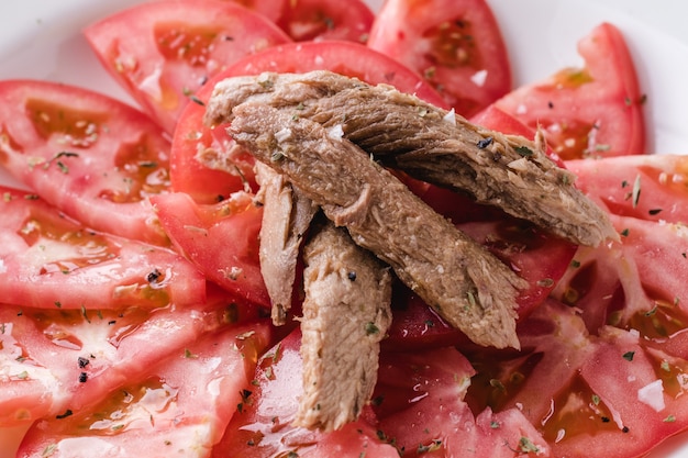 Foto tomate sazonado con melva listo para comer. plato de restaurante español