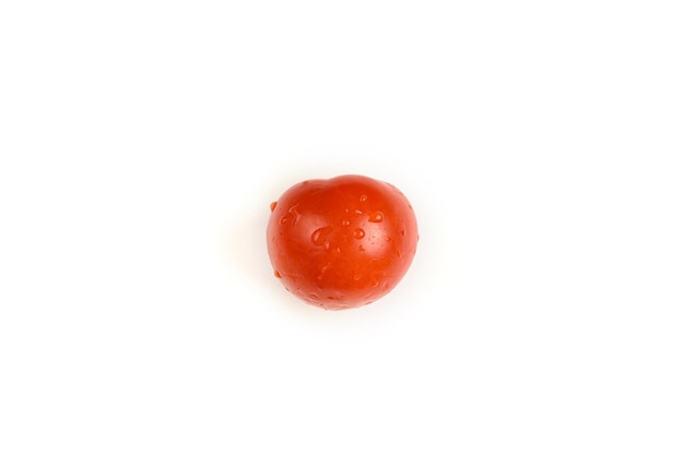 Tomate sin tallo con gotas de agua aislado en blanco