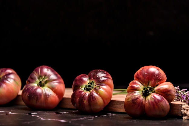 Tomate tigre em uma placa de corte com folhas de manjericão em fundo de madeira Tomate fresco desperdiçado para cozinhar Tomate com gotas de água