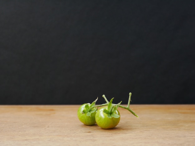 tomate verde em fundo de madeira