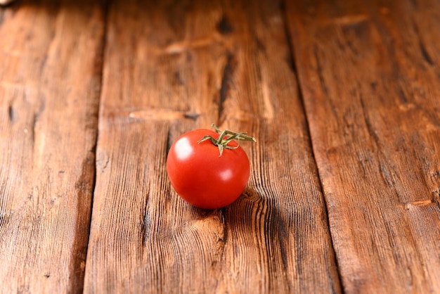 Tomate vermelho maduro em uma mesa de madeira marrom