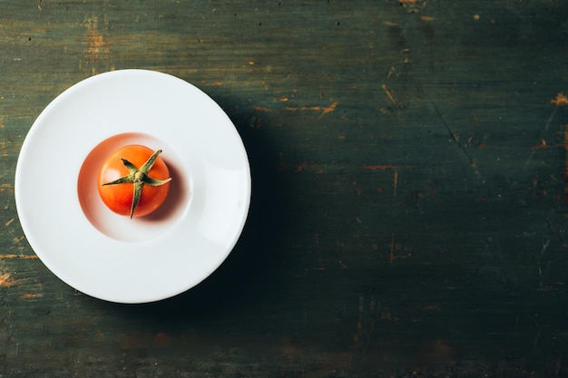 Un tomate en una vista superior de un plato blanco