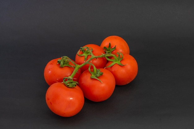 Tomaten auf schwarzem Hintergrund Tomaten mit Schwanz Tomaten stecken zusammen mit einem Schwanz