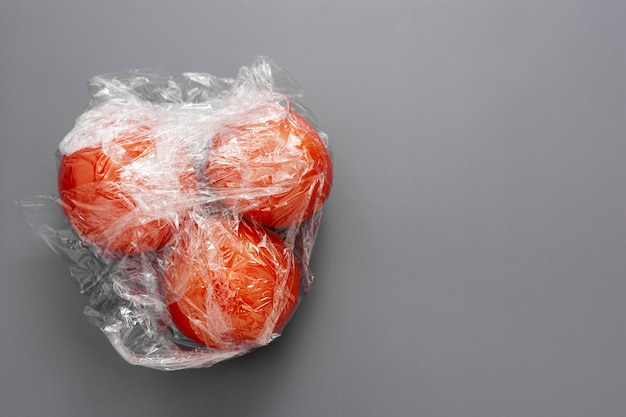 Tomaten in der Verpackung Kunststoff-Stretchfolienrolle, abstraktes Kunststoffabfallkonzept.