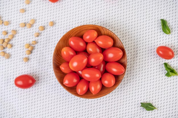 Tomaten in einem Holzbecher auf einem weißen Tuch