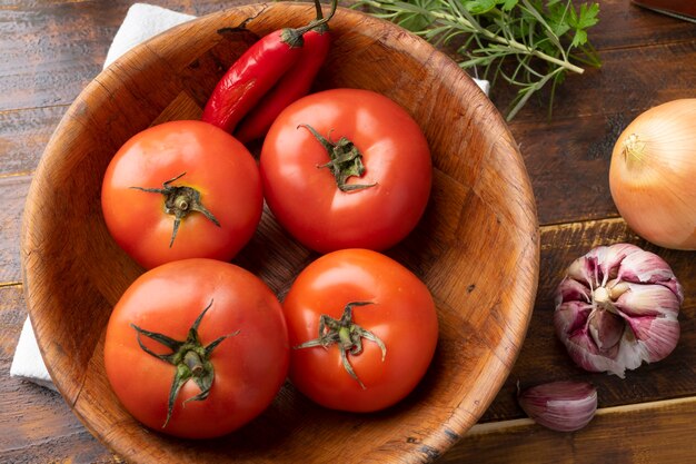 Tomaten, Knoblauch, Paprika und Kräuter über Holztisch.