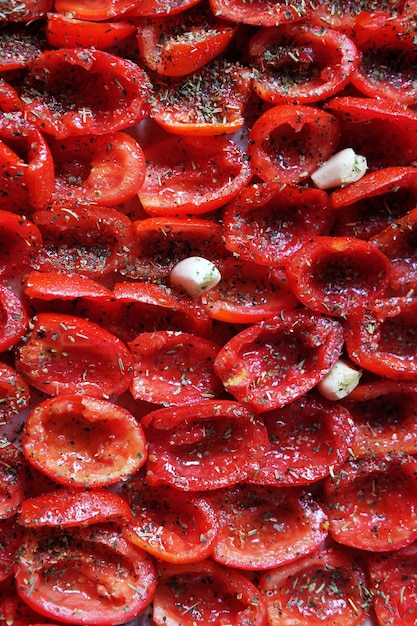 Tomaten liegen auf einem backfertigen Backblech Sonnengetrocknete Tomaten mit Knoblauch Food background close up