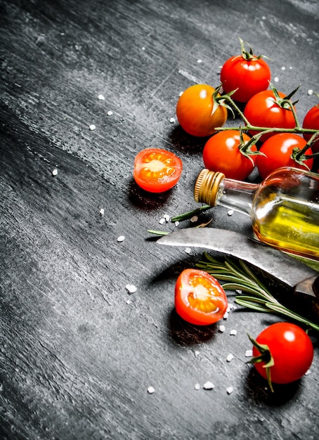 Tomaten mit Olivenöl. Auf schwarzem rustikalem Hintergrund.