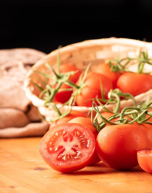 Tomaten schöne Details von frischen roten Tomaten auf Zweigen über selektivem Fokus des rustikalen Holzes