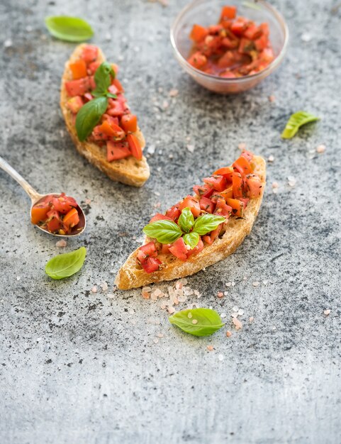 Tomaten- und Basilikum bruschetta Sandwich über Schmutzgrau, Draufsicht.