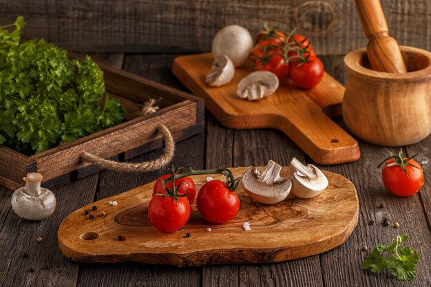 Tomaten und Pilze auf einem Holzbrett