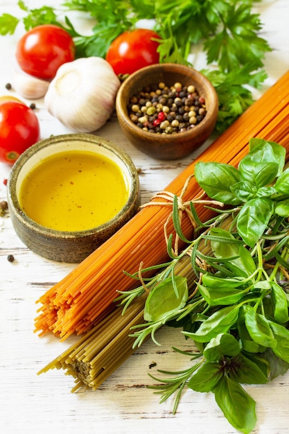 Tomaten und Spinat Spaghetti Kräuter Gewürze Olivenöl und Gemüse auf einem Tisch