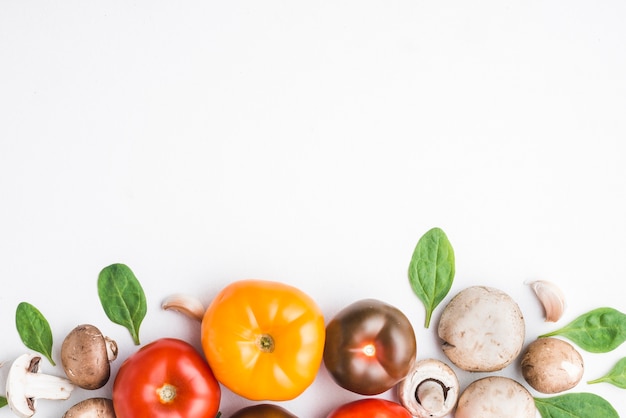 Tomaten unter Spinat und Pilzen