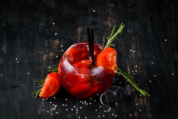 Tomatencocktail Gin Preiselbeersaft Tomaten Eis Auf einem hölzernen Hintergrund Ansicht von oben