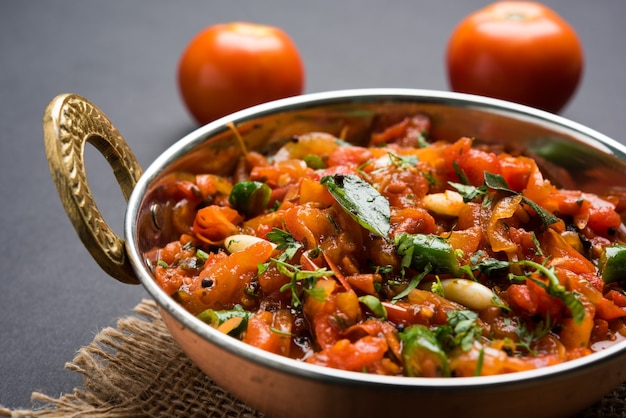 Tomatencurry ODER Sabzi, auch bekannt als Sabji oder Chutney, serviert in Schüssel, beliebtes indisches Gemüsemenü für Hauptgericht. selektiver Fokus