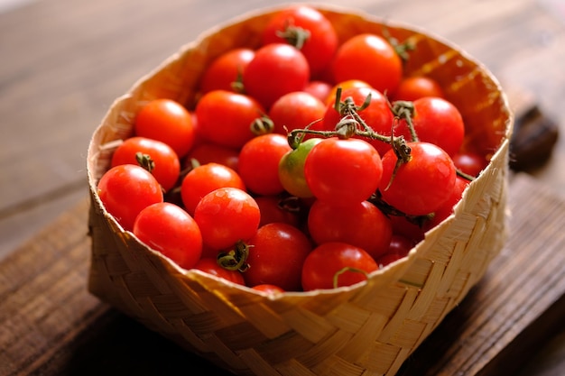 Tomatenkirsche im geflochtenen Bambuskorb. solanum lycopersicum var. Cerasiform. rund klein.