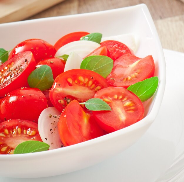 Tomatenkirschsalat mit Basilikum, schwarzem Pfeffer und Zwiebeln