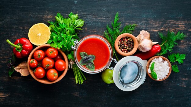 Tomatenmark Ketchup mit hausgemachtem Gemüse Draufsicht auf schwarzem Hintergrund Freier Platz für Text