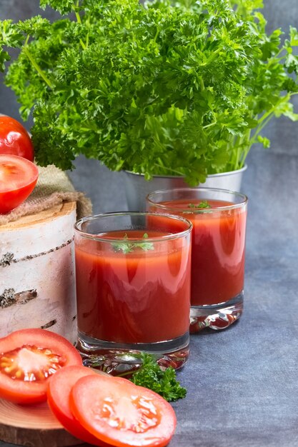 Tomatensaft in Gläsern steht auf einem Holzstumpf