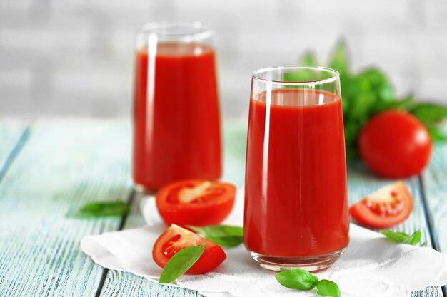 Tomatensaft und frische Tomaten auf Holztisch Nahaufnahme