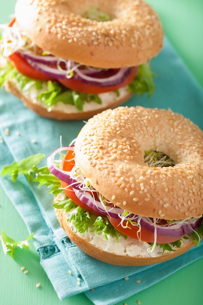 Tomatensandwich auf Bagel mit Frischkäse-Zwiebel-Salat-Luzerne-Sprossen